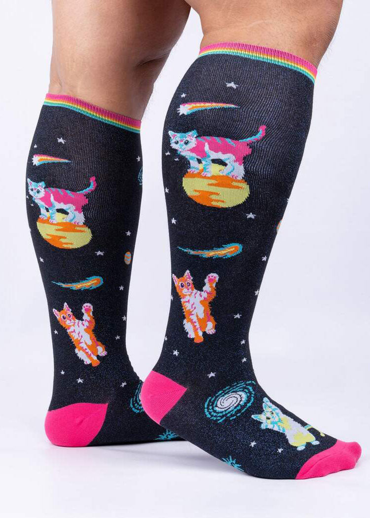 Knee socks with a dark blue metallic on black background depict colorful cats in space among comets, stars and planets.