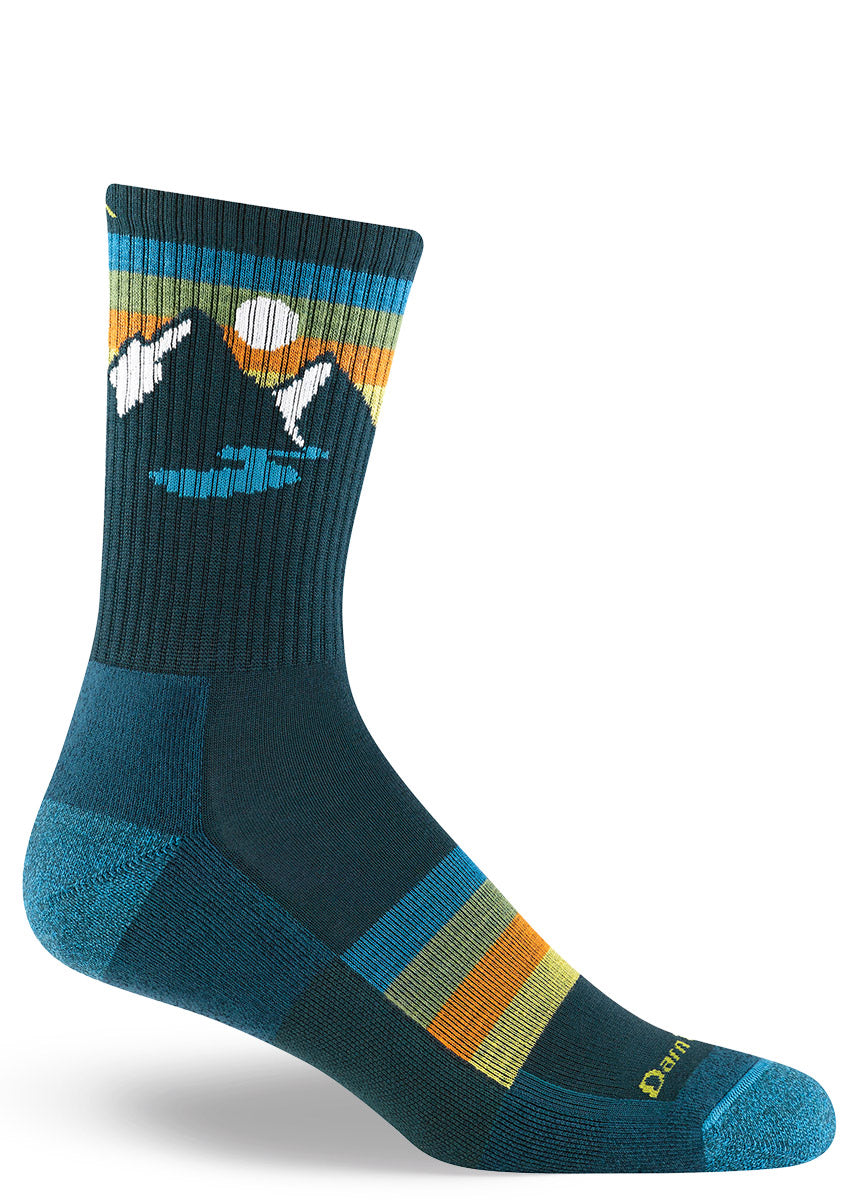 Dark teal and navy merino wool hiking socks for men in a multicolor design with mountains, rivers and sunset skies.