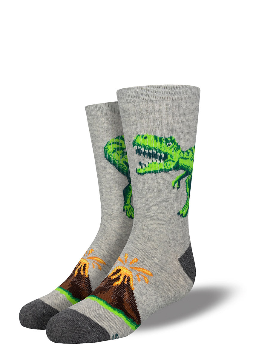 Dinosaur socks for children have a big T. rex raging on a gray background with a volcano erupting on the top of each foot.