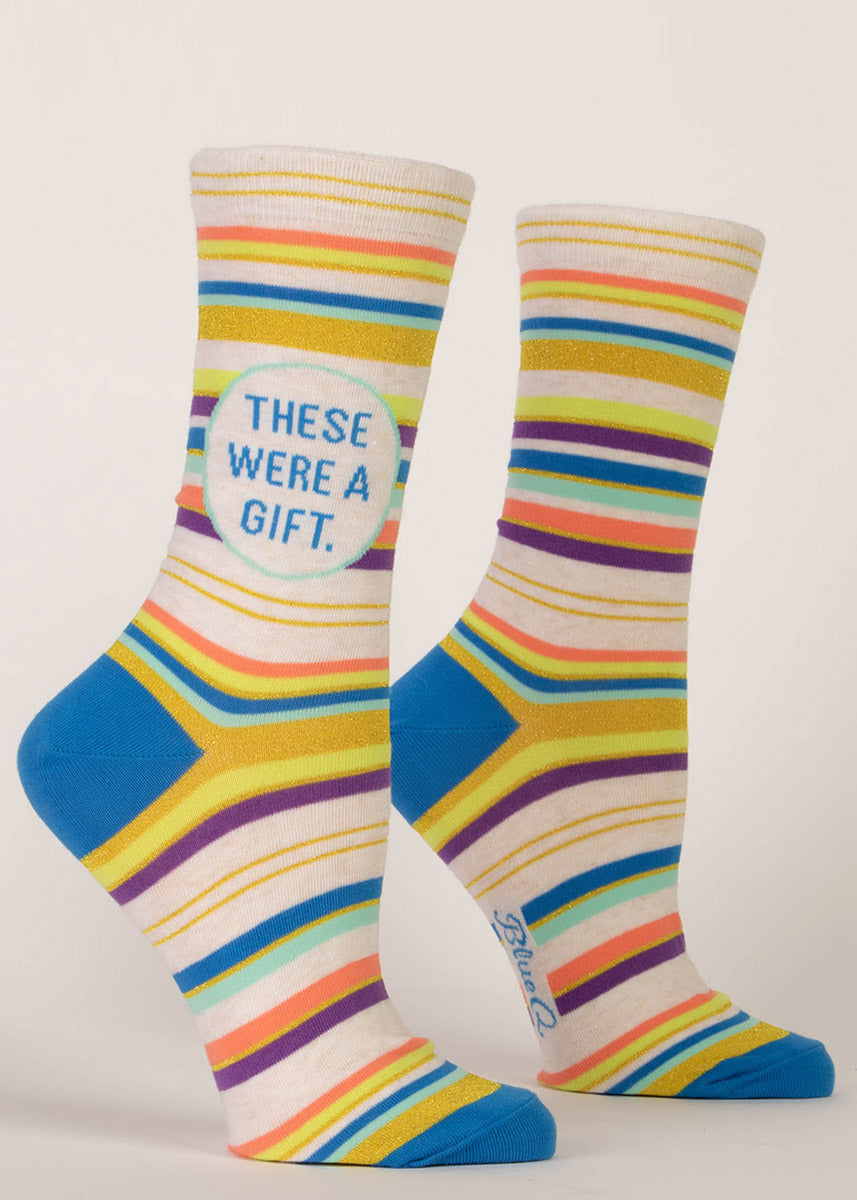 Striped crew socks with shimmery gold glitter and the words “These Were A Gift.” 
