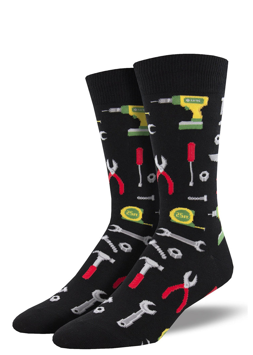 Crew socks for men feature tools like drills, wrenches, hammers, and more on a black background!