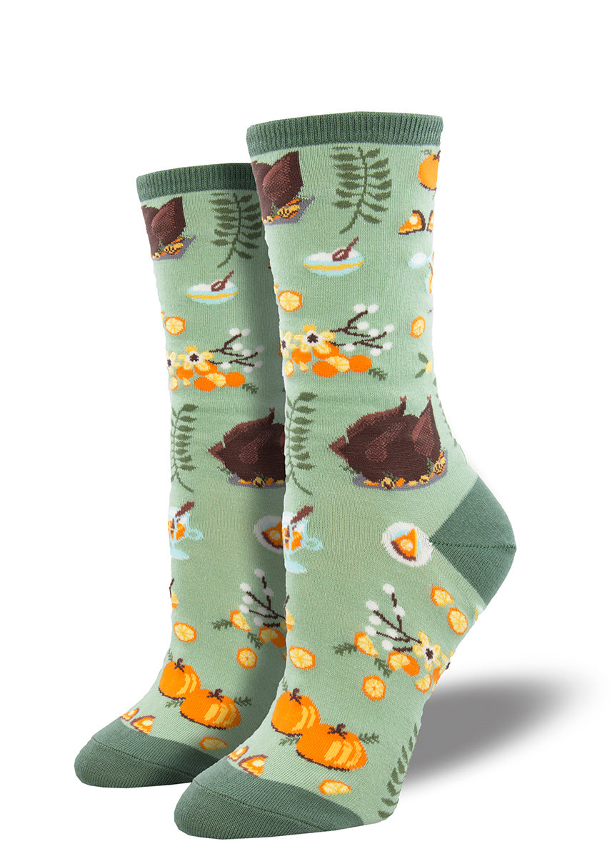 Thanksgiving socks for women show a roasted turkey, pumpkins and slices of pumpkin pie, and fall greenery.
