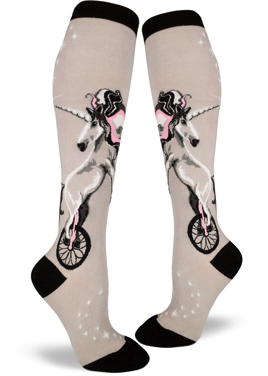 Unicorn knee-high socks for women with unicorns riding unicycles with pink and silver shimmer accents on light gray socks