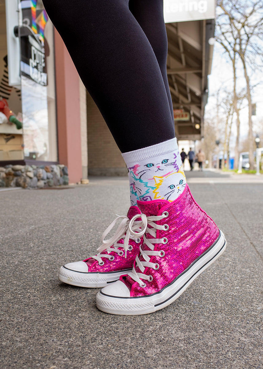 White cat faces outlined in pastel colors on women's crew socks.