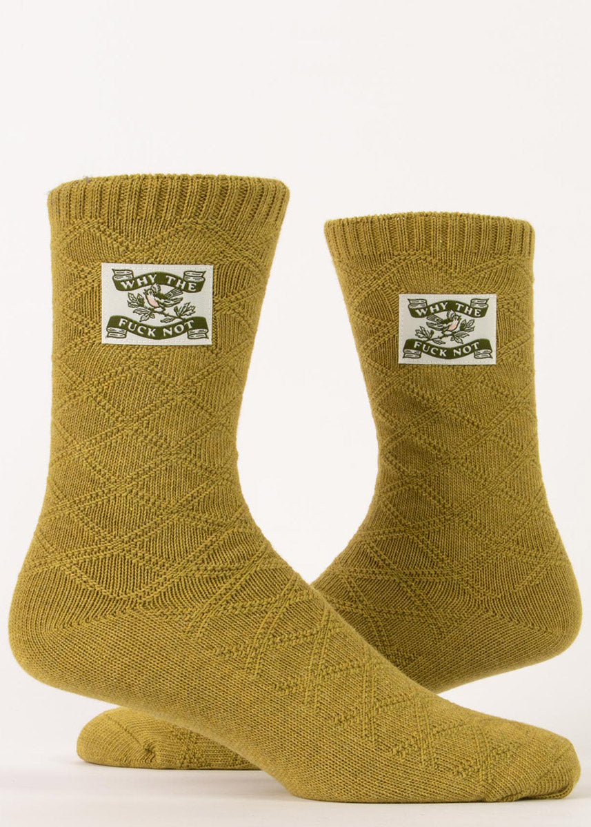 Funny swear word socks feature tags that show a little bird on a branch with the words, &quot;Why the fuck not,&quot; on an olive green diamond-knit background.