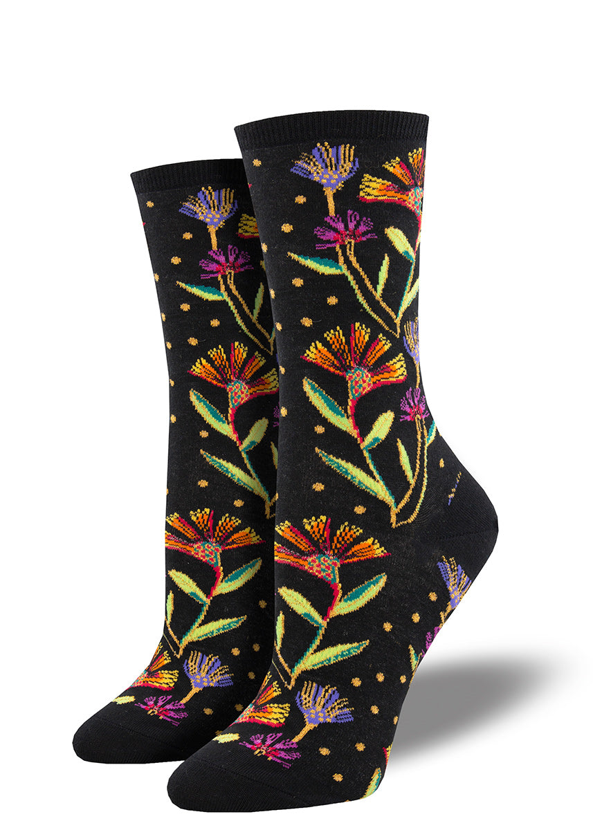 Laurel Burch socks with purple and orange wildflowers on a black background.