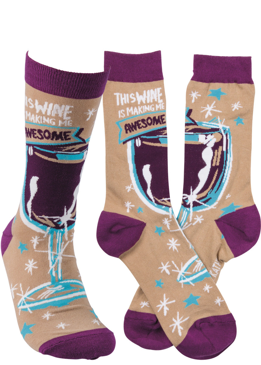 Funny wine socks show a glass of red on a tan background with the words, &quot;This wine is making me awesome.&quot;