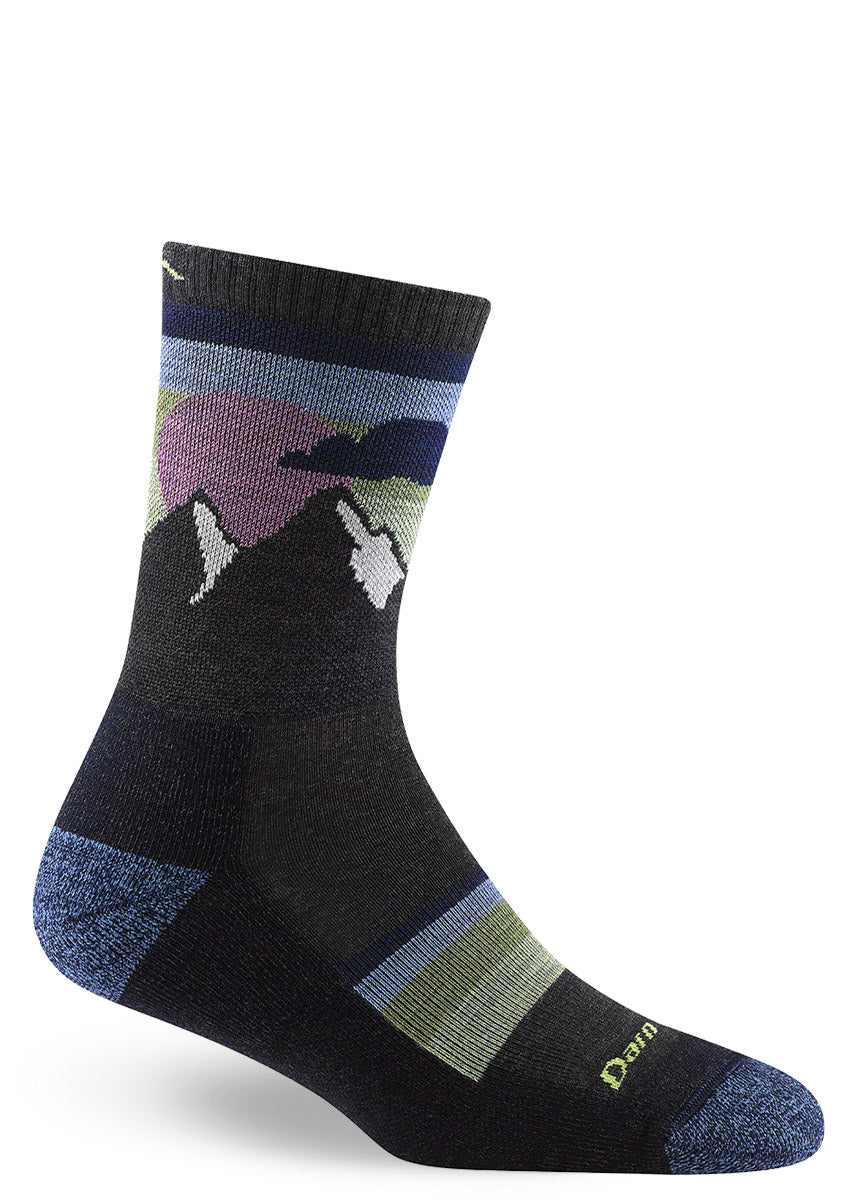Charcoal hiking socks with snow-capped mountain peaks and a big blue-green sky with a pink sun.