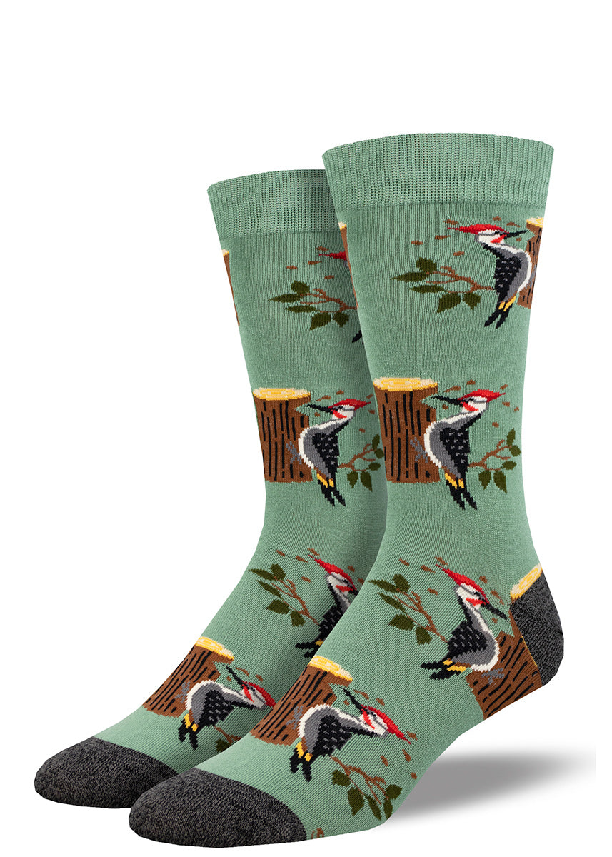 Green crew socks for men with a repeating pattern of a woodpecker bird chipping away at a tree trunk.