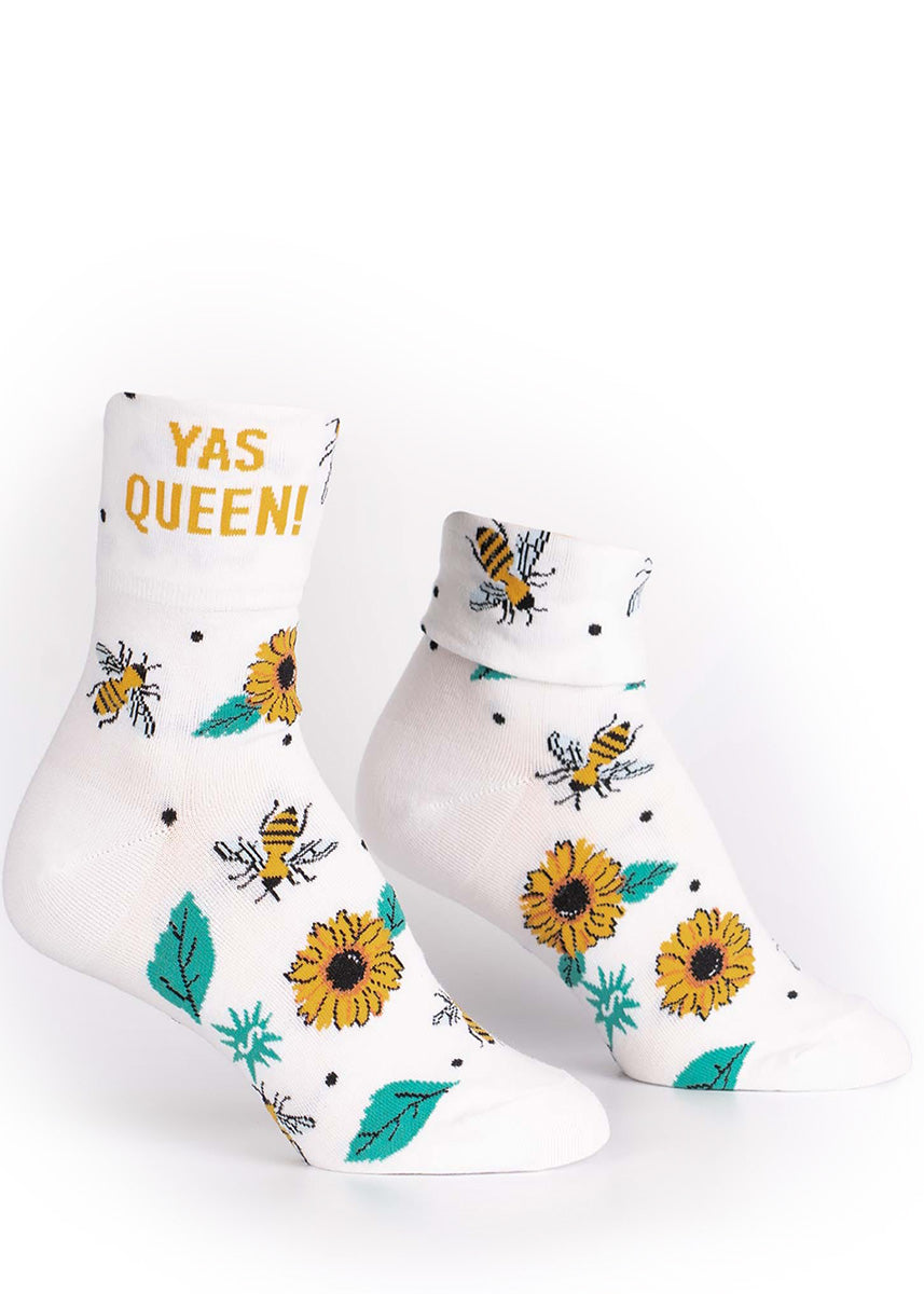 Cuffable socks for women feature bees and yellow flowers, and say "YAS QUEEN" when uncuffed.